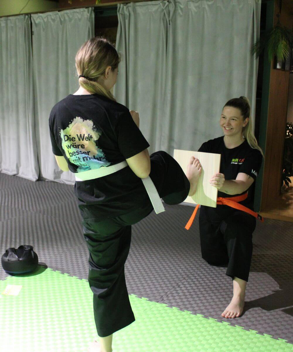 Bretttest — Kind tritt gegen Holzbrett, Coach hält es fest